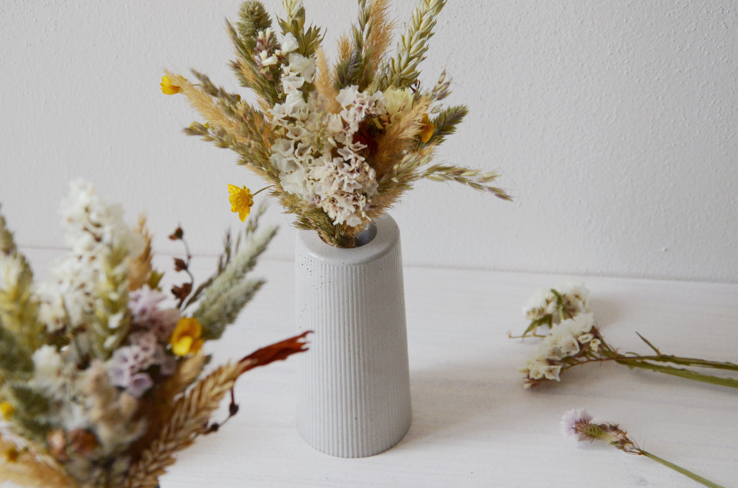 concrete vase with dried flowers Květina sušená v betonové vázičce - světle šedá. Close up. Front point of view.