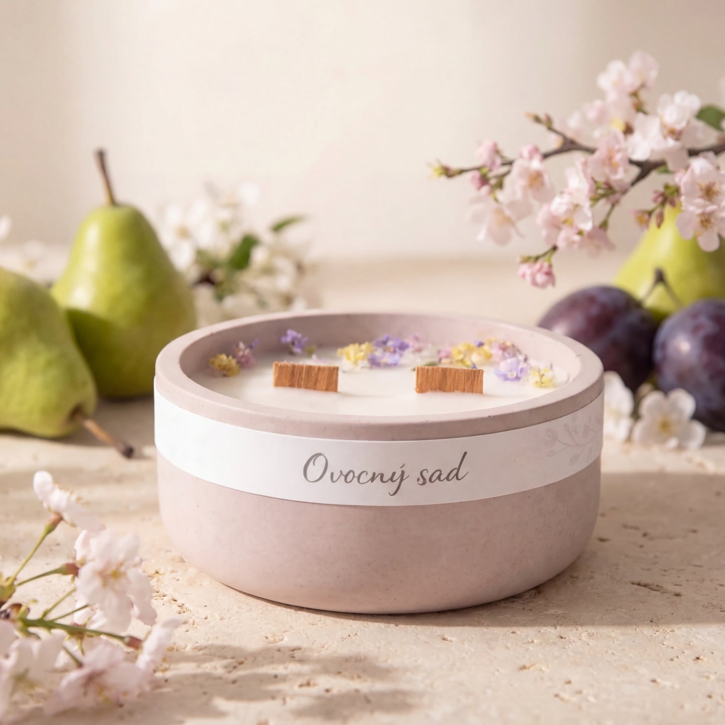 Přírodní vonná svíčka s vůní hrušky, švestky a třešňového květu v minimalistické světlé produktové fotografii.