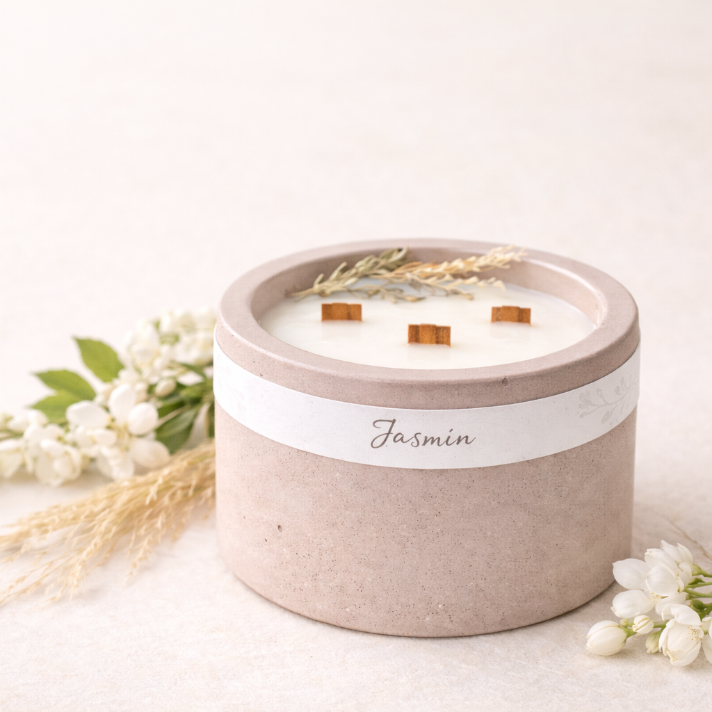 Detail sójové svíčky Jasmín s třemi dřevěnými knoty a jemnými botanickými prvky, v matném betonovém obalu ve starorůžové barvě.