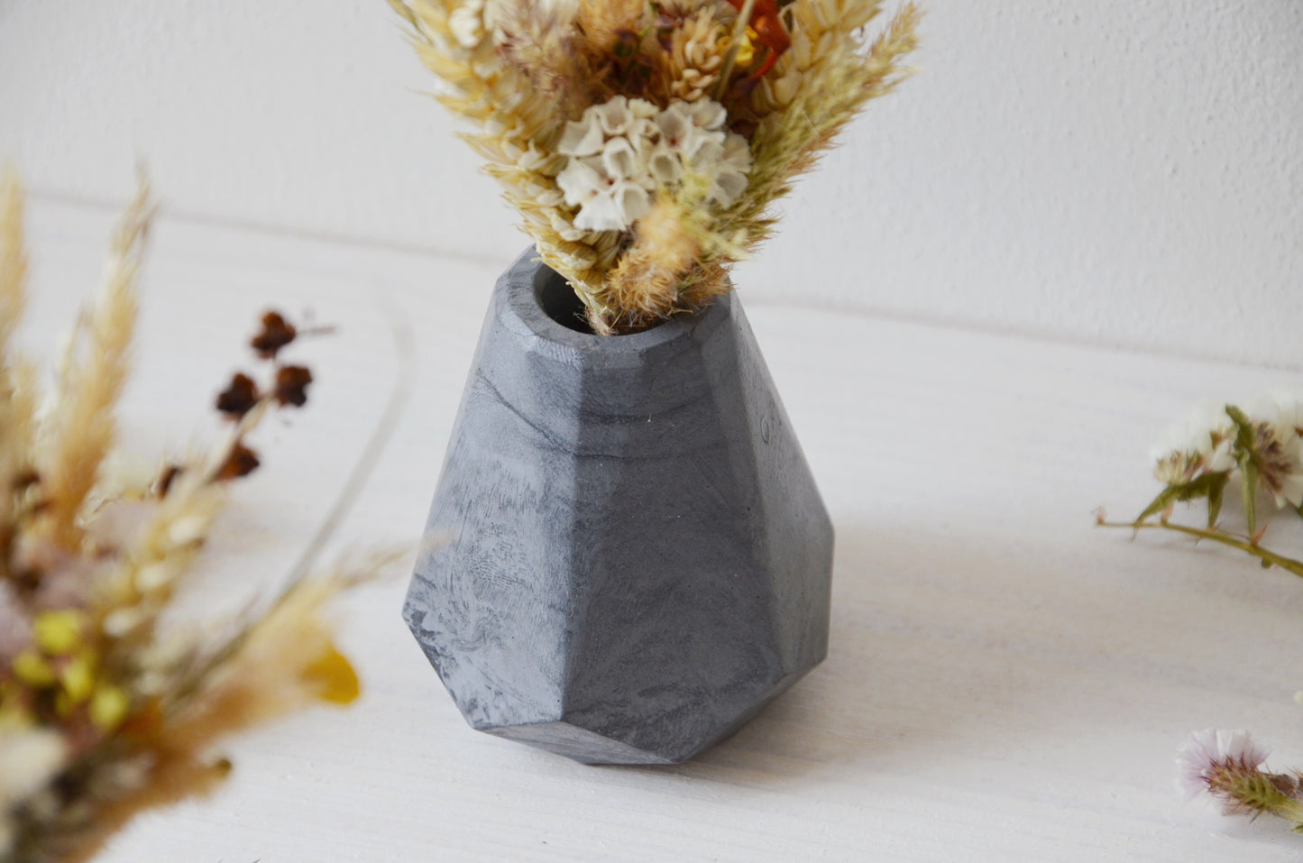 concrete vase with dried flowers Květina sušená v betonové vázičce - tmavě šedá diamant. Front point of view. Close up.