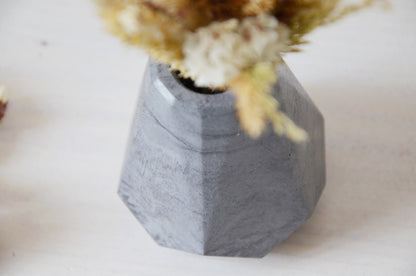 concrete vase with dried flowers Květina sušená v betonové vázičce - tmavě šedá diamant. Close up. Point of view from above