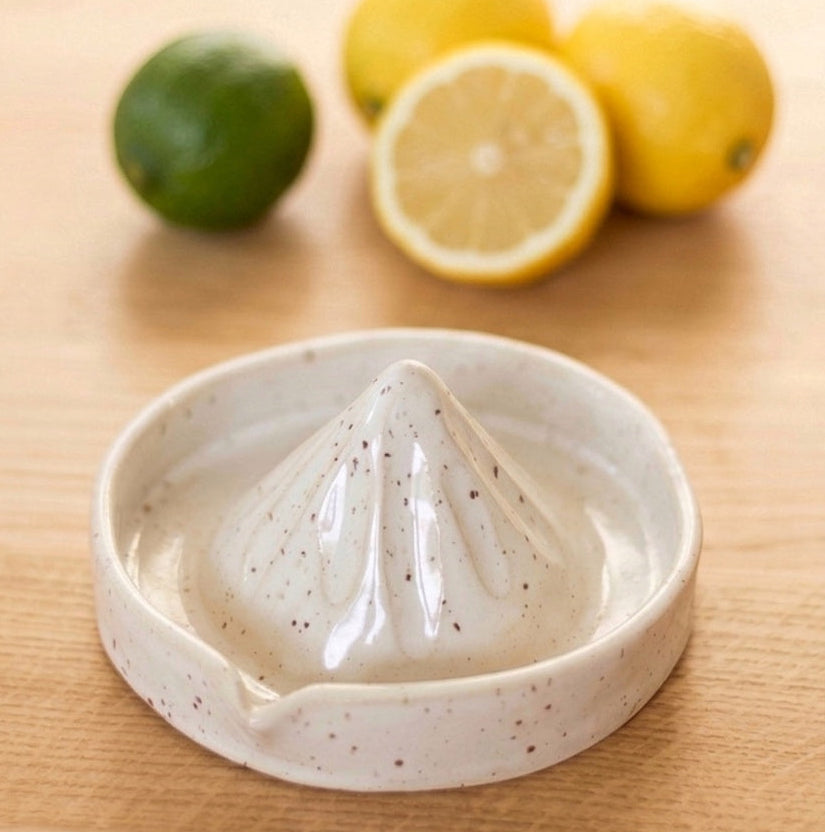 Bílý keramický lis na citrony na kuchyňské lince