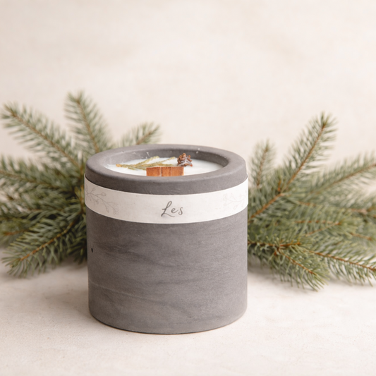 Ručně vyráběná sojová svíčka s vůní lesa v matné keramické nádobě, s dřevěným knotem a přírodními detaily, focená na světlém krémovém pozadí s jemně rozostřenou lesní větvičkou