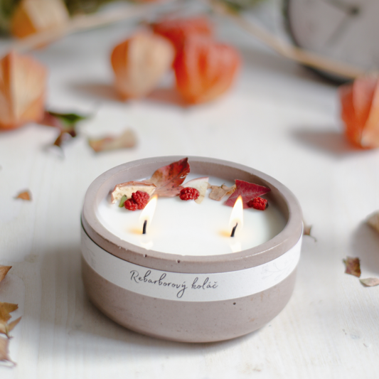 Rebarborová svíčka s vůní rebarborového koláče, aranžovaná v podzimní atmosféře. s bavlnenymi knoty