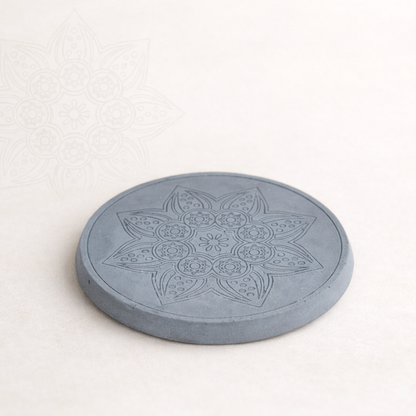 Ručně vyráběný betonový podtácek s jemným mandalovým motivem, focený v minimalistickém přírodním stylu na světlém pozadí.